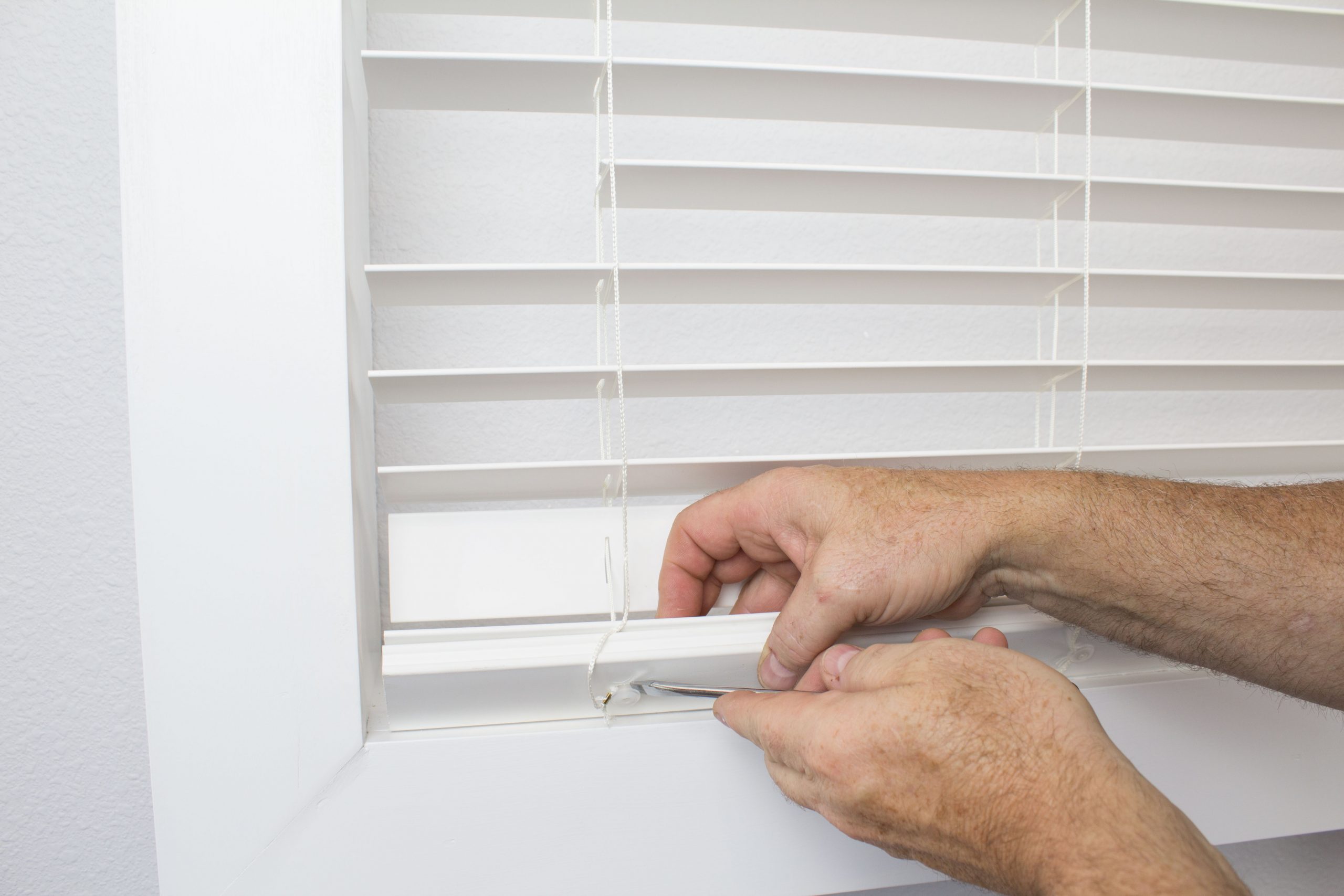 Pull lift string out with pliers and remove knot.